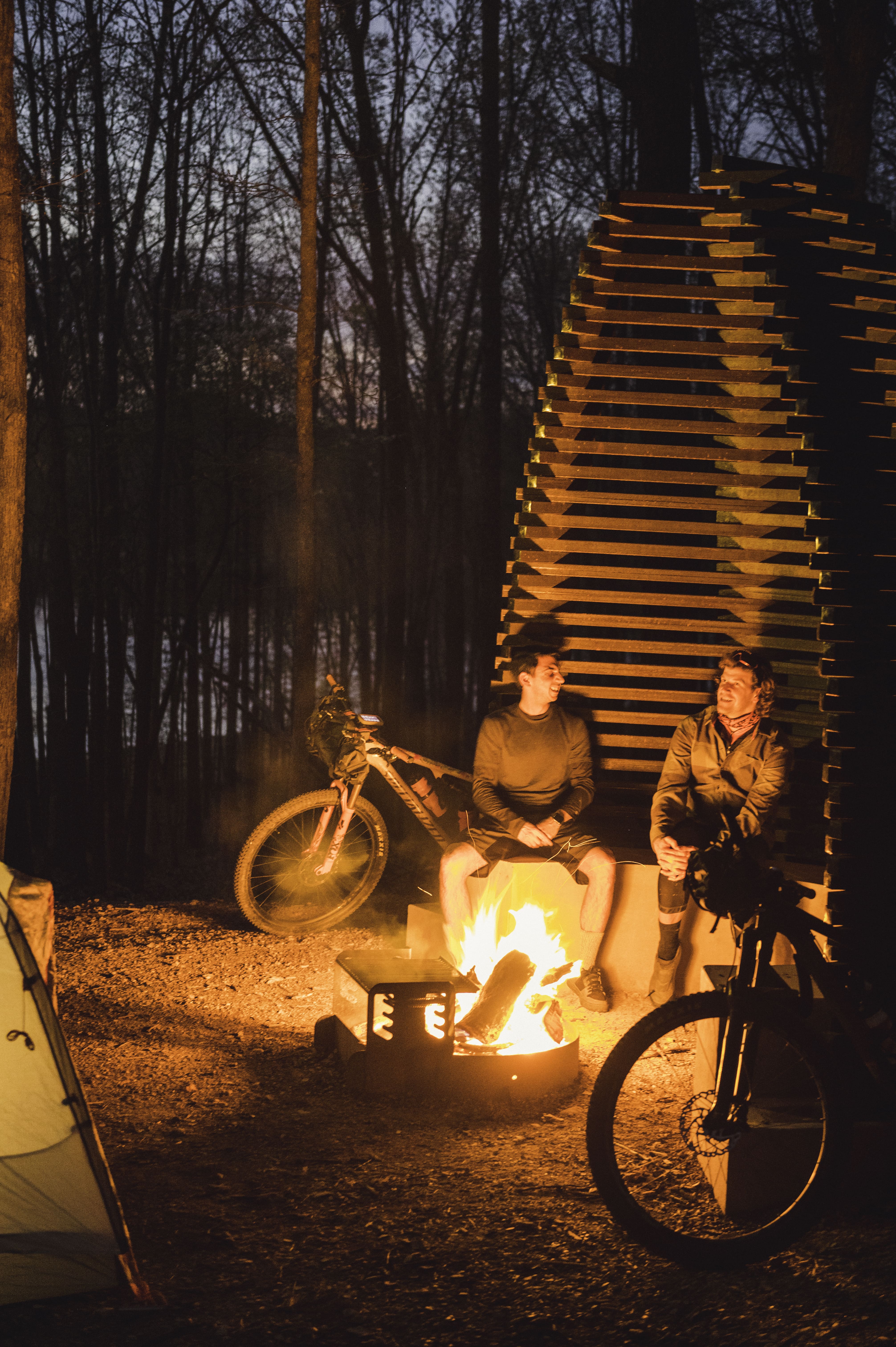 Two mountain bikers camping and sitting around the fire on the Monument Trails at Hobbs State Park-Conservation Area